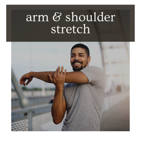 Smiling runner pulling one straight arm across the chest with the opposite hand to stretch the shoulder